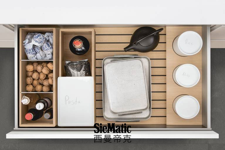 Porcelain containers, bottles and other supplies on SieMatic GripDeck with wooden kitchen accessories